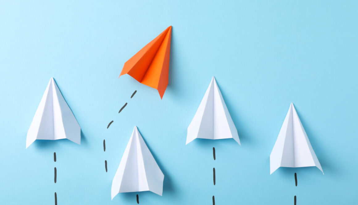 Paper airplanes on blue background, space for text