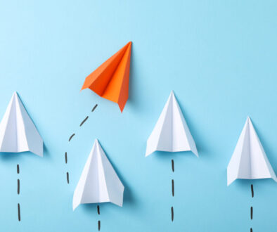 Paper airplanes on blue background, space for text