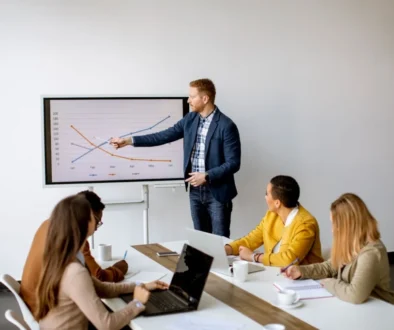 A business team in a meeting examines a chart that illustrates the financial implications of hiring full-time employees versus rightsourcing.
