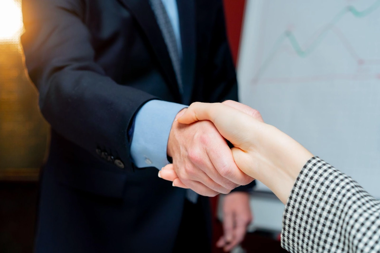 Two business people shaking hands representing the cost of commission errors between agents and BGAs or Carriers.